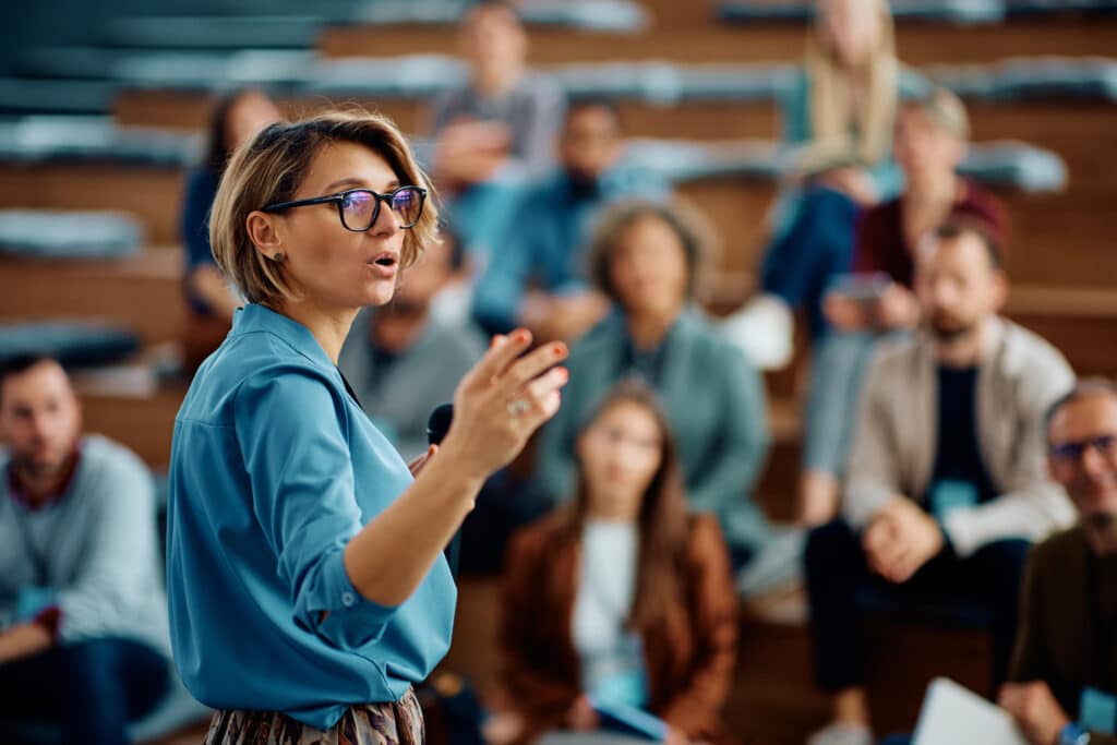 Woman speaking to room of peers